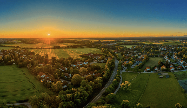 The sun rises over the horizon of a small rural community